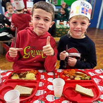 Plant Ysgol Pentreuchaf yn bwyta cinio nadolig ac yn gwisgo siwmper nadolig