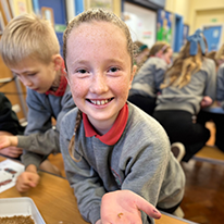 Plentyn Ysgol Pentreuchaf yn gafael pryfyn yn ei llaw